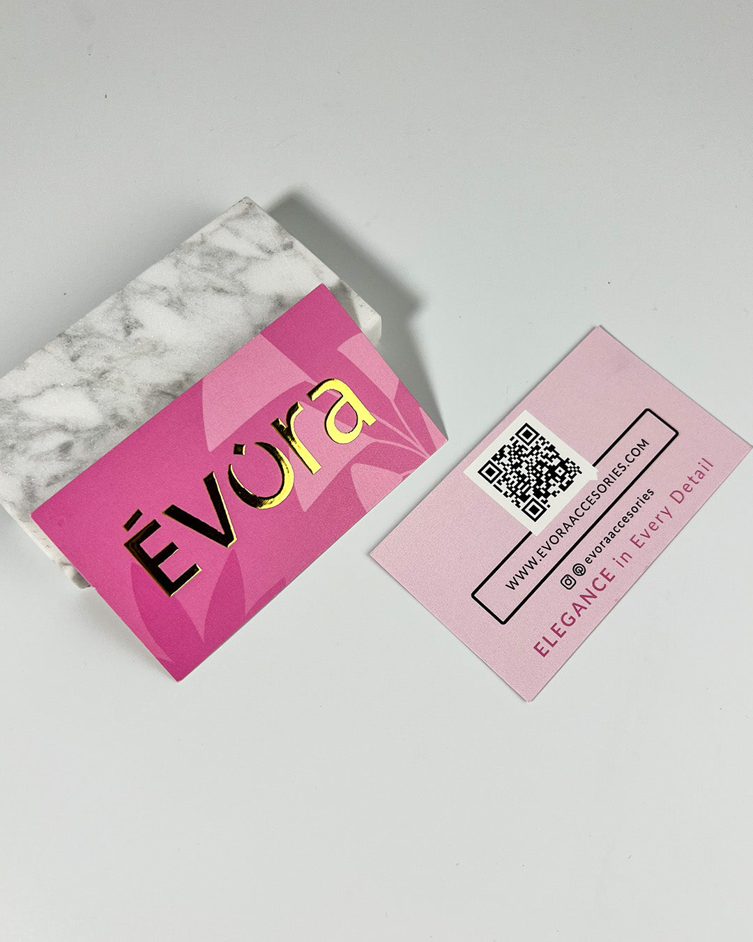 Pink business card with 'Evéra' branding on a marble surface